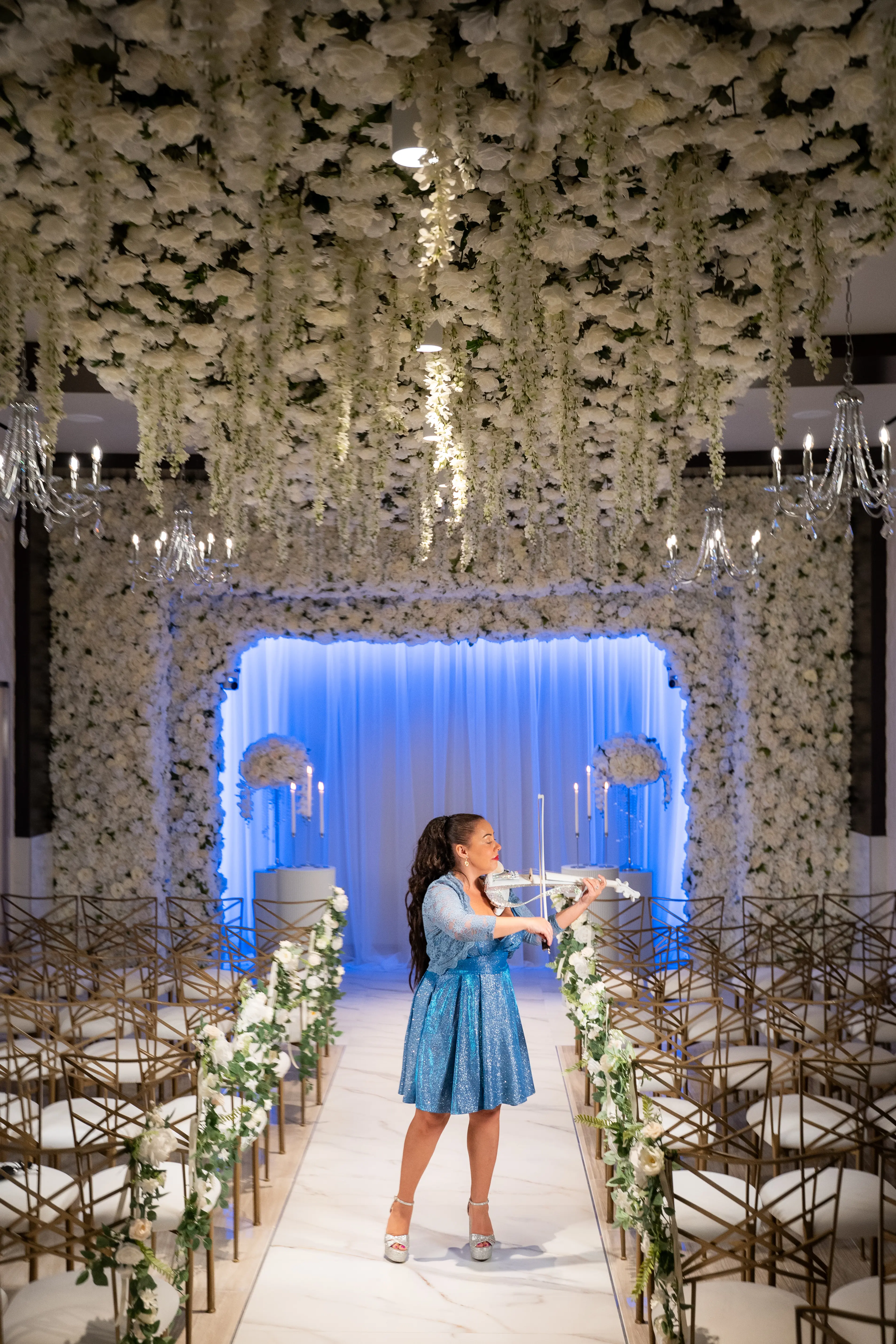Felicia playing violin in a classic hall