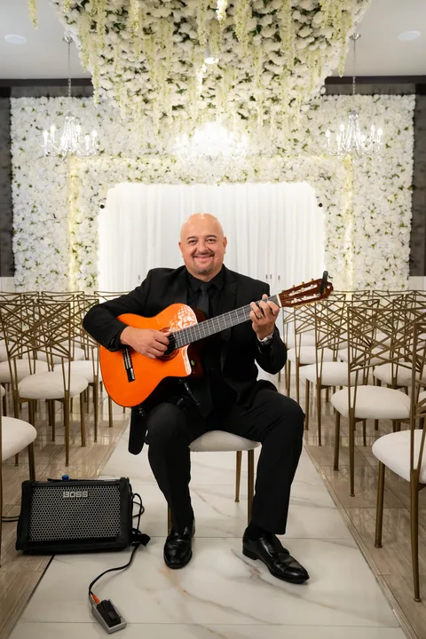 Hans seated under chandelier