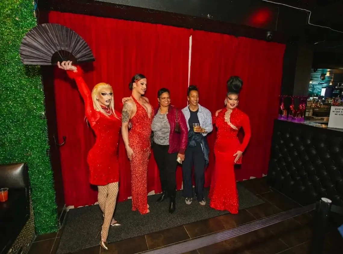 Drag queen posing with a feather fan